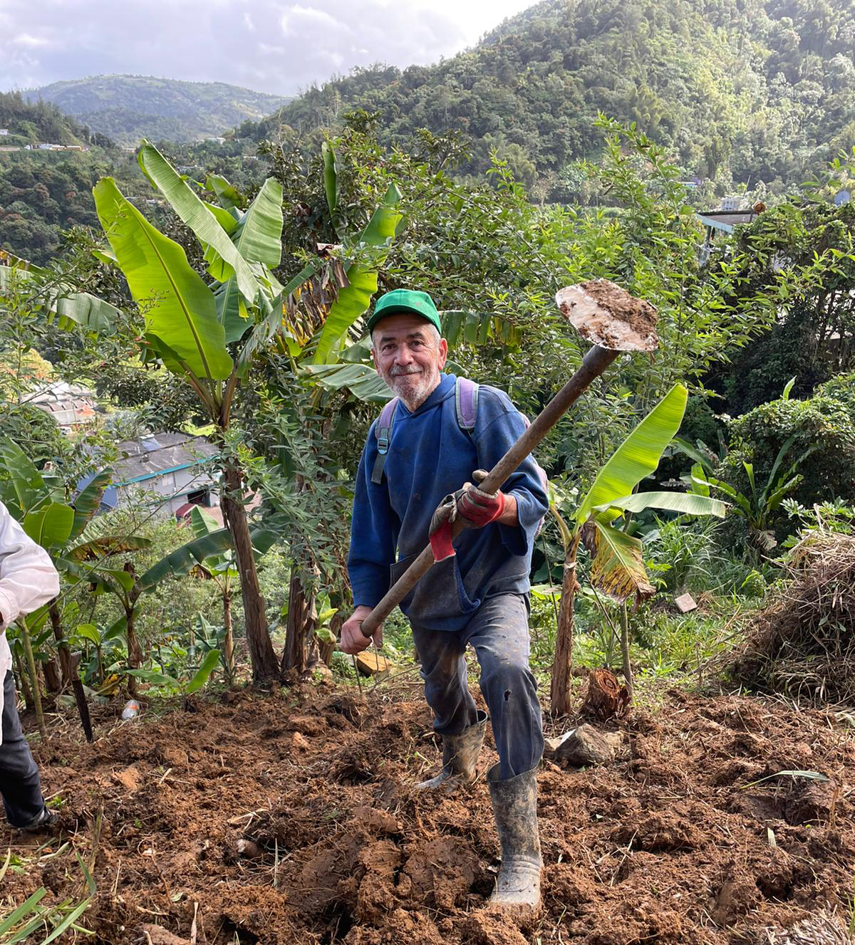 Carlos, un vecino de San Salvador, en su platanal tirando la tierra con una azada