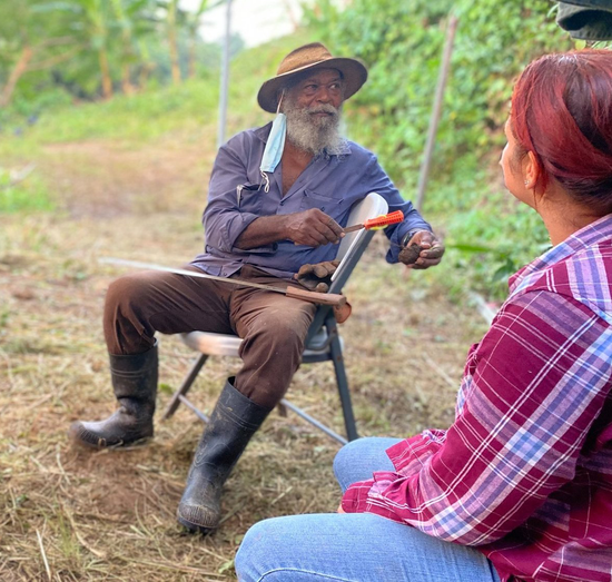 Imagen de hombre agricultor hablando con otra persona como parte del programa de Abono.